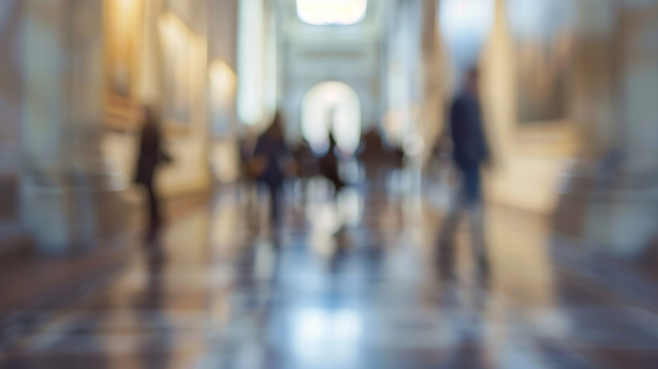 Abstract blurred interior of a modern museum with soft ambient lighting.